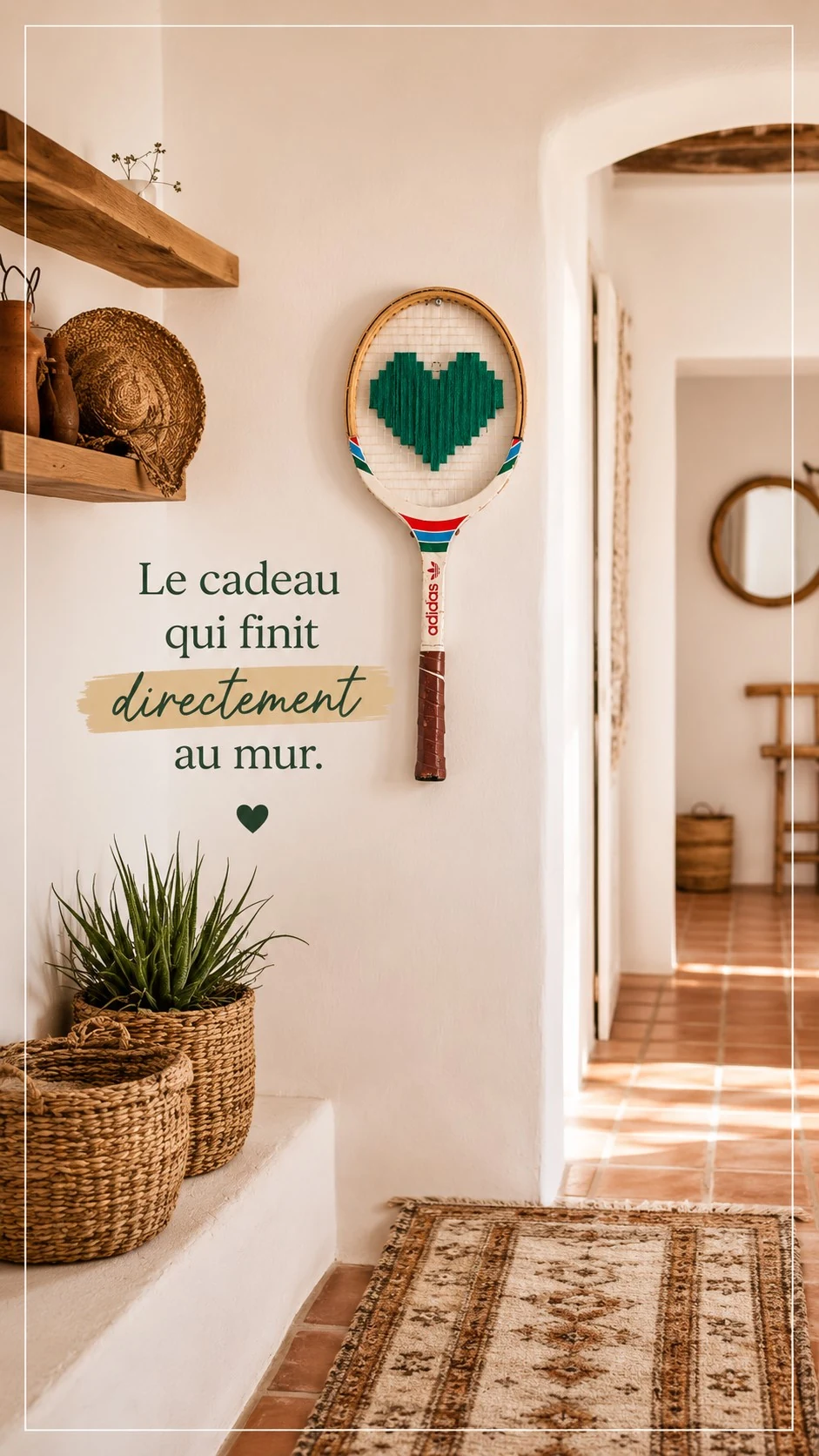 Raquette vintage au cœur vert brodé accrochée dans une entrée claire